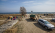 People walking by the Baltic sea beach near the mobile sauna parked by the beach are seen...
