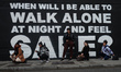 Young women pose for a picture in front of a new mural by Irish artist Emmalene Blake in D...