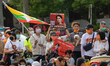 Group of People holding signs and portraits of  Myanmar official Leader Aung San Suu Kyi d...