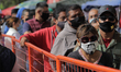 Dozens of people are waiting in line to enter the Mercado de la Viga market located in Mex...