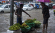 DHAKA, BANGLADESH  27th June : Street hawcker selling vegitables in waterlogged streets du...