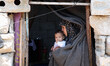 A Palestinian woman holds her child outside her family home consider that suffer extreme p...
