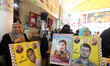 Relatives of Palestinians imprisoned in Israeli jails hold pictures of Khader Adnan, a Pal...