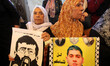 Relatives of Palestinians imprisoned in Israeli jails hold pictures of Khader Adnan, a Pal...
