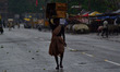 An indian woman carries boxes on her head during rains,in Allahabad on June 29,2015. 