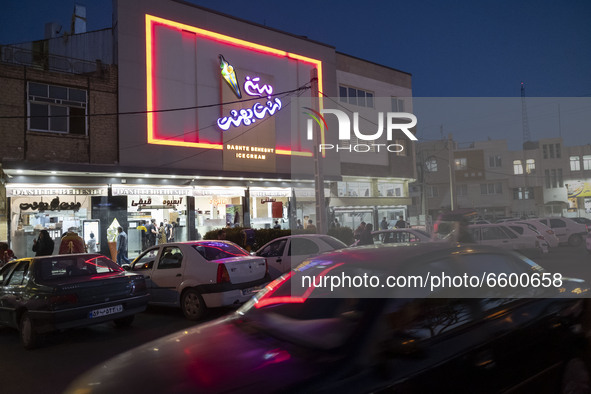 Vehicles are parked in front of an ice cream shop in the holy city of Qom, 145Km (90 miles) south of Tehran at night amid the new coronaviru...