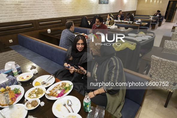 Iranian women living in the holy city of Qom, 145Km (90 miles) south of Tehran, speak with each other as they sit at a restaurant amid the n...