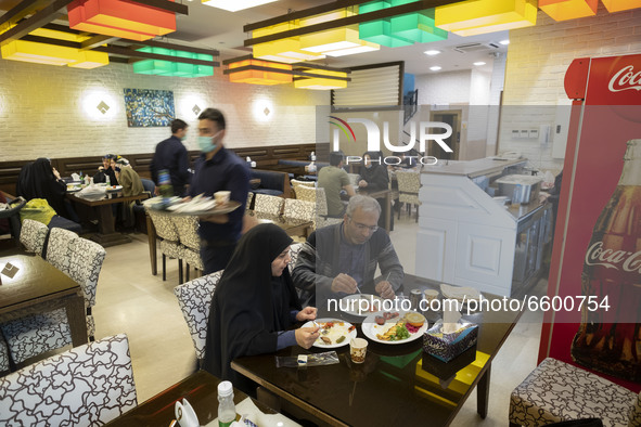 An Iranian couple living in the holy city of Qom, 145Km (90 miles) south of Tehran, eat meal at a restaurant amid the new coronavirus diseas...