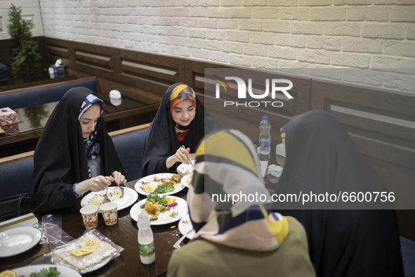 Iranian veiled women living in the holy city of Qom, 145Km (90 miles) south of Tehran, eat meal at a restaurant amid the new coronavirus dis...
