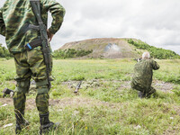 Soldier shoots under the surveillance of a military  instructor of the DPR army in the outskirts of Donetsk city on June 29, 2015. (
