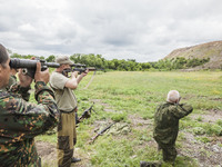Soldiers shoot under the surveillance of a military  instructor of the DPR army in the outskirts of Donetsk city on June 29, 2015. (