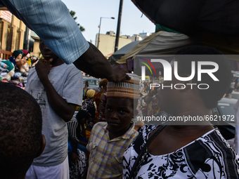A Muslim boy shop for a traditional Nigerian cap at the entrance of the Lagos Central Mosque (Lagos Island) located along the busy Nnamdi Az...