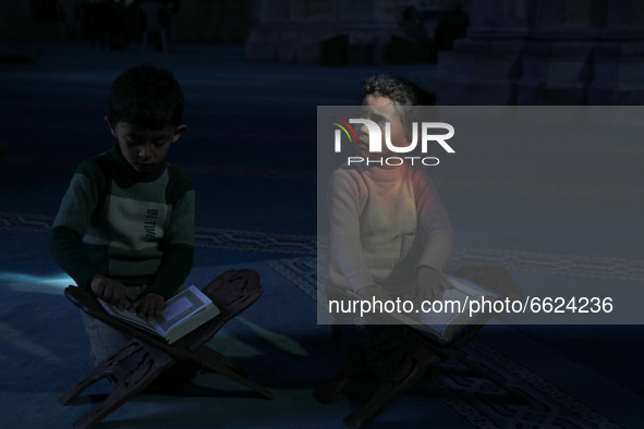  Palestinian children reads a copy of the Koran in Al Omari mosque during the Muslim holy month of Ramadan, in Gaza City, on April 16, 2021....
