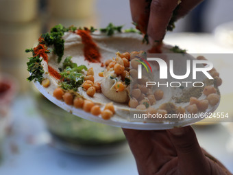 A Palestinian vender prepare chickpeas known as hummus for breakfasting during the Muslim fasting month of Ramadan in Gaza City on April 16,...