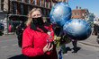 WINDSOR, UNITED KINGDOM - APRIL 17, 2021: A woman holds balloons and a crocheted figure po...