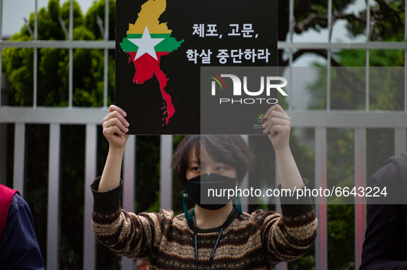 A South Koean activist holds a banner that says, Stop The Civilian Massacre, during a press conference outside of Indonesian Embassy in Kore...