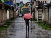 Kashmir men with umbrella on a rainy day amid COVID-19 Coronavirus Pandemic in Sopore, District Baramulla, Jammu and Kashmir, India on 22 Ap...