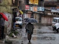 Kashmir men with umbrella on a rainy day amid COVID-19 Coronavirus Pandemic in Sopore, District Baramulla, Jammu and Kashmir, India on 22 Ap...