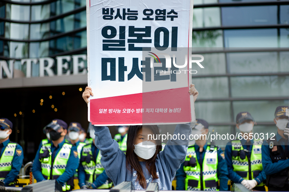 A protester holds a banner say the Japanese Government Should Drink Fukushima Radioactive Contaminated Water during a protest against the Ja...