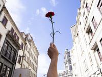 A woman holds a red carnation during a demonstration to commemorate the anniversary of Portugal's Red Carnations revolution in the city of P...
