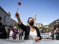 A woman holds a red carnation during a demonstration to commemorate the anniversary of Portugal's Red Carnations revolution in the city of P...