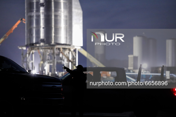 A security guard checks technicians credentials at the entrance to Starship SN15's launch pad on the evening on April 25th, 2021 at SpaceX's...