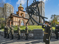 Soldiers show their respects in the memorial site about the Chernobyl catastrophe during the celebrations in Kiev, Ukraine, on April 26, 202...