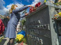 A woman lays flowers in a  memorial about Chernobyl catastrophe during the celebrations in Kiev, Ukraine, on April 26, 2021 of the 35th anni...