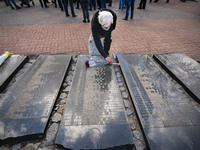 A man lays flowers in the memorial of the dead Chernobyl workers during the celebrations in Kiev, Ukraine, on April 26, 2021 of the 35th ann...