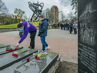 A boy puts flowers in a  memorial during the celebrations in Kiev, Ukraine, on April 26, 2021 of the 35th anniversary of the Chernobyl  nucl...