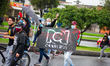 Demonstrators carry a metal fence from the Private TV Channel RCN in Bogota, Colombia on A...