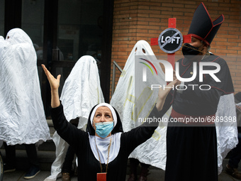 Ghosts culture workers stand with actors playing a bishop and a nun with a cross. Disguised culture workers (actors, live artists, dancers,...