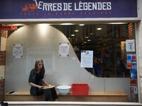 An actress plays in the store front of a comics' library. Disguised culture workers (actors, live artists, dancers, musicians, technicians,...