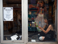 Two actress play in a bookshop front window.  Disguised culture workers (actors, live artists, dancers, musicians, technicians, etc.),and co...
