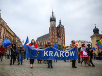 People walk through the Main Square during celebration of 17-year of Polish membership in the European Union. Krakow, Poland on May 1st, 202...