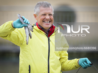 Scottish Liberal Democrat leader Willie Rennie holds up some fish as he plays with a group of penguins at Edinburgh Zoo on May 3, 2021 in Ed...