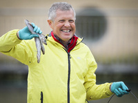 Scottish Liberal Democrat leader Willie Rennie holds up some fish as he plays with a group of penguins at Edinburgh Zoo on May 3, 2021 in Ed...