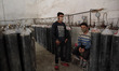 Worker rests as they waits for cylinders to refill at an oxygen refiiling facility as dema...