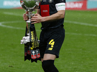 Josh Falkingham of Harrogate Town  holds The Buildbase FA Trophy during  The 2019/2020 Buildbase FA Trophy Final between Concord Rangers and...