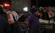 Paramedics transfer an injured person on a stretcher to be taken to a hospital after the c...