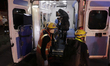 Paramedics transfer an injured person on a stretcher to be taken to a hospital after the c...