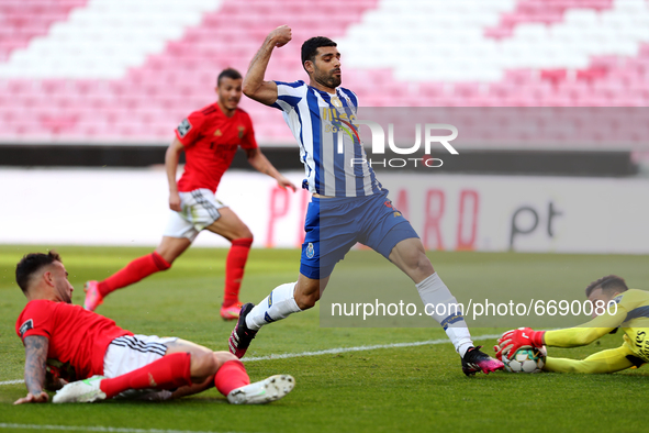 Mehdi Taremi of FC Porto (C ) vies with Benfica's goalkeeper Helton Leite (R ) during the Portuguese League football match between SL Benfic...