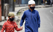  Kashmiri boys wearing face masks walks in old city as Corona curfew continues across the...