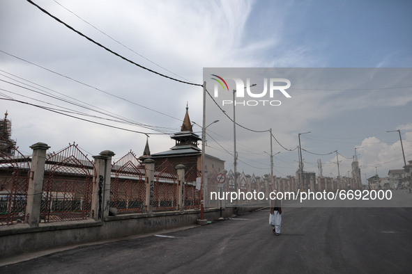 A man walks on the deserted street outside Kashmir's grand mosque during Covid-19 lockdown on the last friday of Ramadan in Srinagar, Indian...