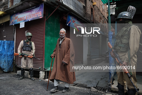 A Kashmiri man walks as Indian troops stand outside Kashmir's grand mosque during Covid-19 lockdown on the last friday of Ramadan in Srinaga...