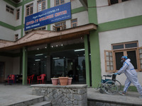 A Health walks with a wheelchair at a temporary Covid-19 hospital in Srinagar, Indian Administered Kashmir on 08 May 2021. A Local NGO Athro...