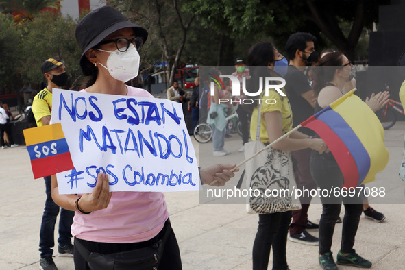 A Colombian woman holds a placard while joins a demonstration at Monument of Revolution to protest against the repression and killings in Co...