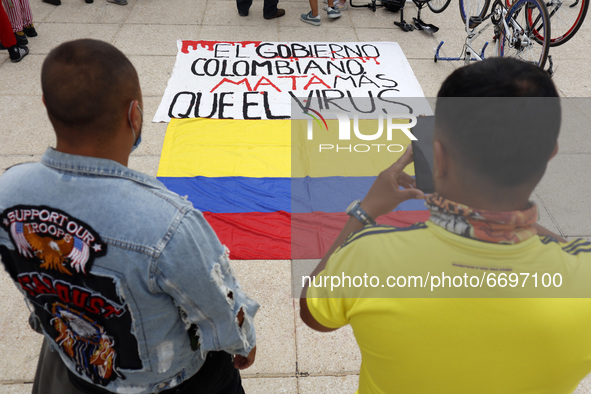 Persons  take a photo of a Colombian flag while join a demonstration at Monument of Revolution to protest against the repression and killing...