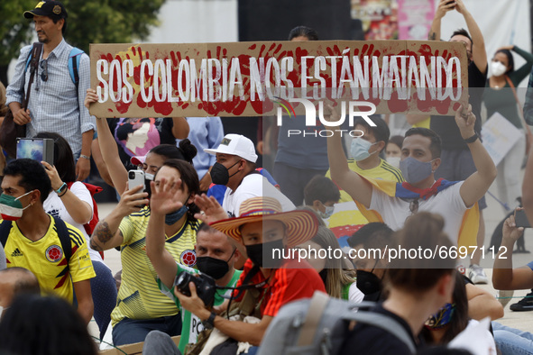 A person holds a placard while joins a demonstration at Monument of Revolution to protest against the repression and killings in Colombia of...