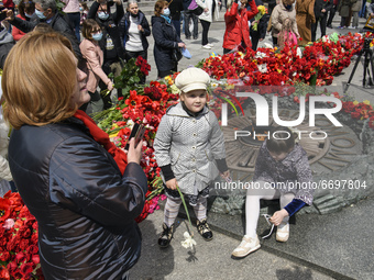 Woman takes pictures of children near the Tomb of the Unknown Soldier as they marks the Victory Day, the 76th anniversary of the victory ove...